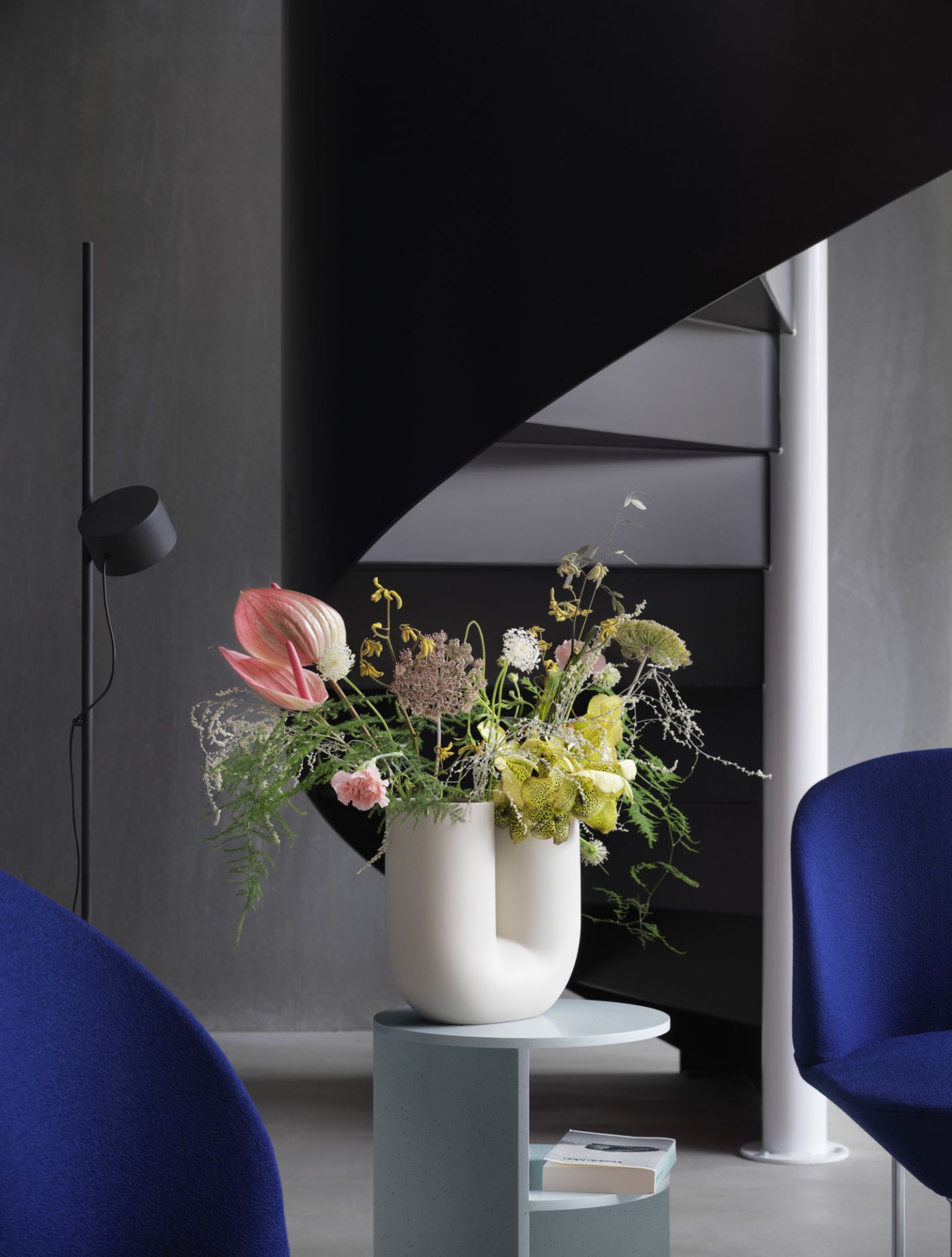 Dekorative Kink Vase in Sand von Muuto mit Blumenarrangement auf einem Beistelltisch.