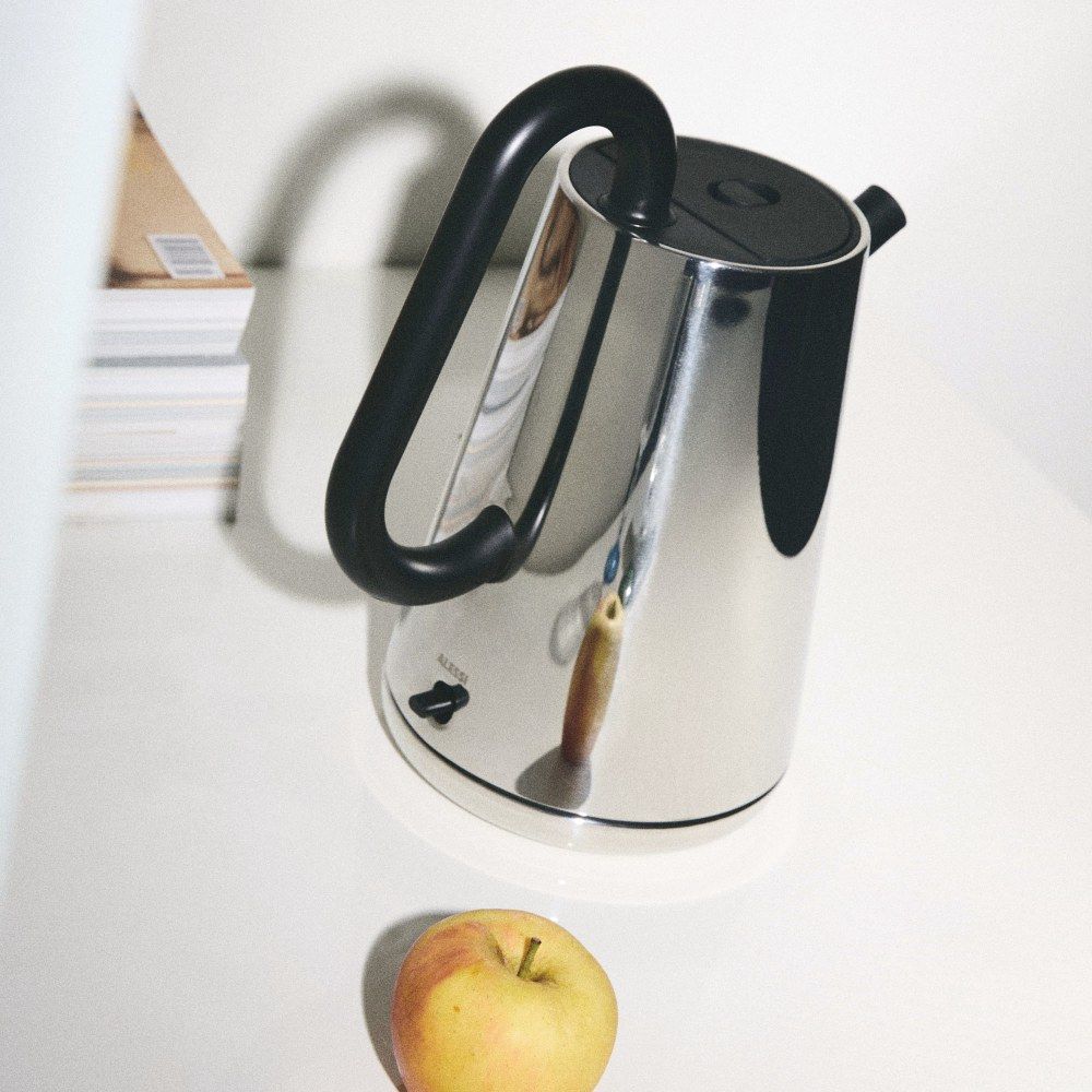 Alessi NE01 B Toru Wasserkocher aus Edelstahl mit schwarzem Griff und Apfel.