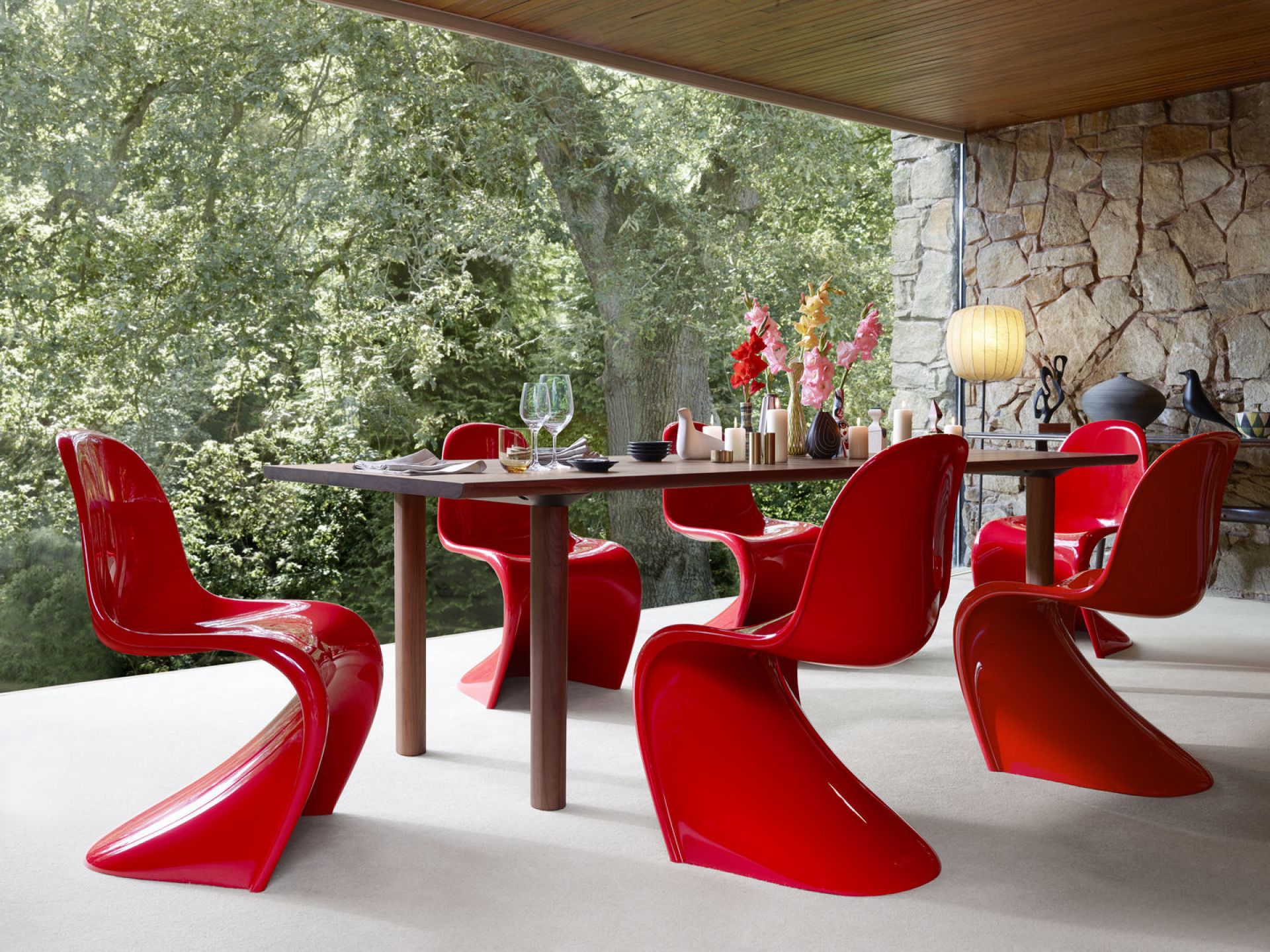 Rote Panton Chair Stühle von Vitra um einen Esstisch auf einer Terrasse.
