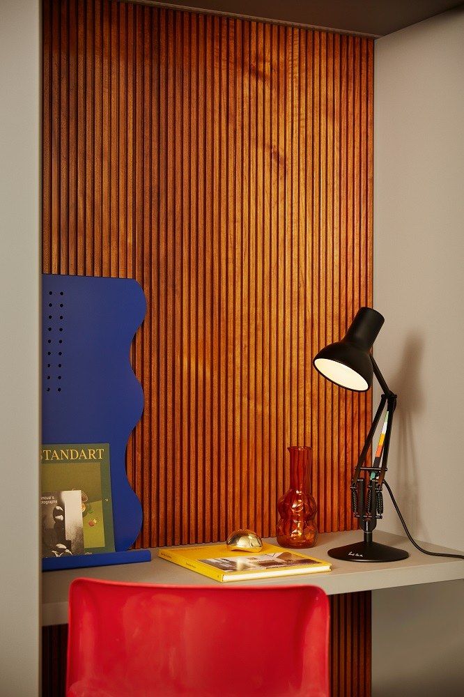 Anglepoise Type 75 Mini Paul Smith Edition Tischleuchte auf Schreibtisch mit rotem Stuhl.