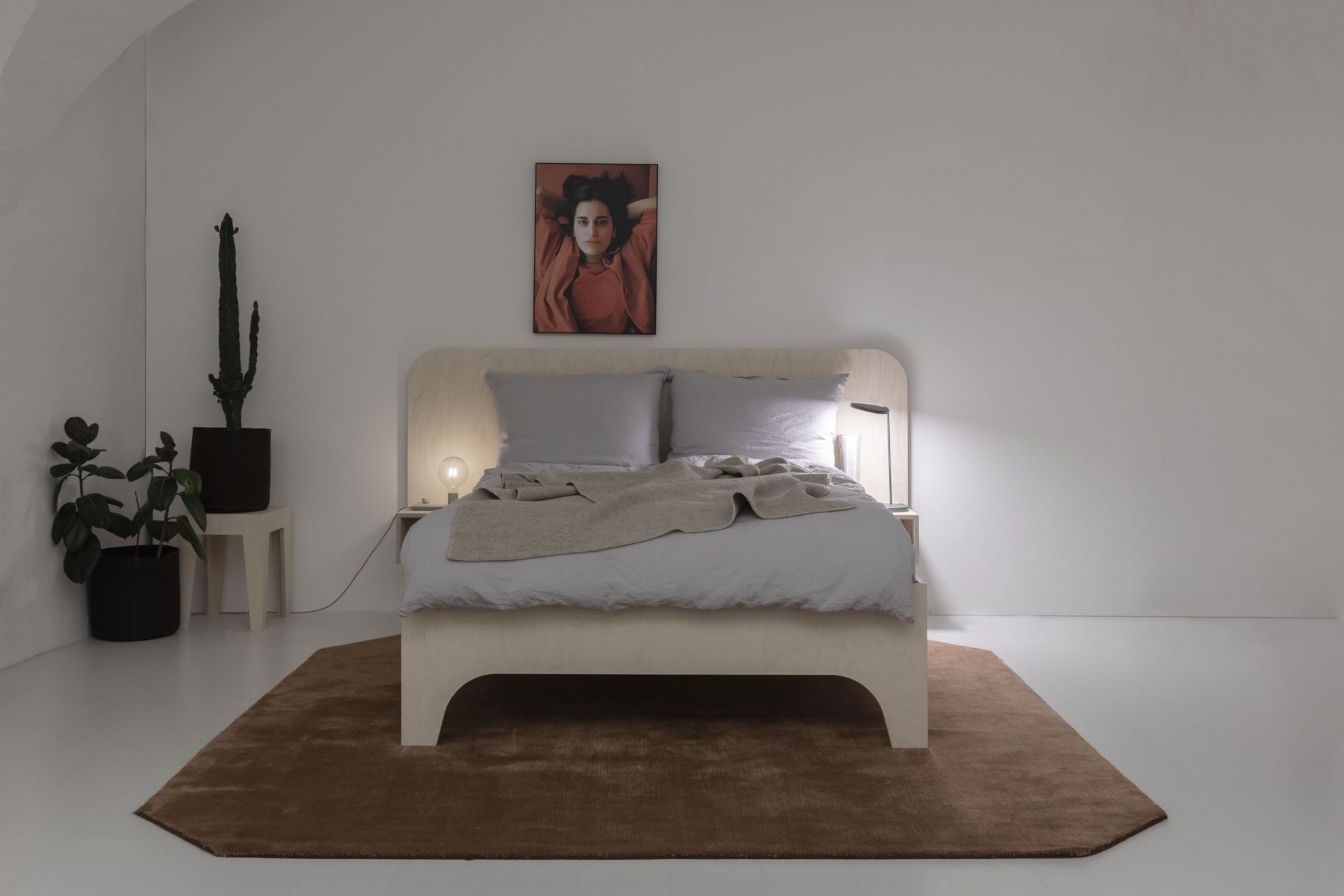 VALENTINA Bett 180x200 cm in Schwarz mit hellgrauer Bettwäsche und beiger Tagesdecke auf braunem Teppich.