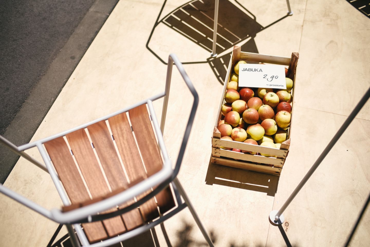 Osmo Stuhl von Prostoria: Moderner Outdoor Stuhl aus Holz und Metall neben Äpfeln.