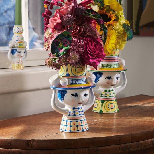 Keramikvase "Lady with Hat" von Bjorn Wiinblad mit bunten Blumen und verspieltem Design auf einem Holztisch.