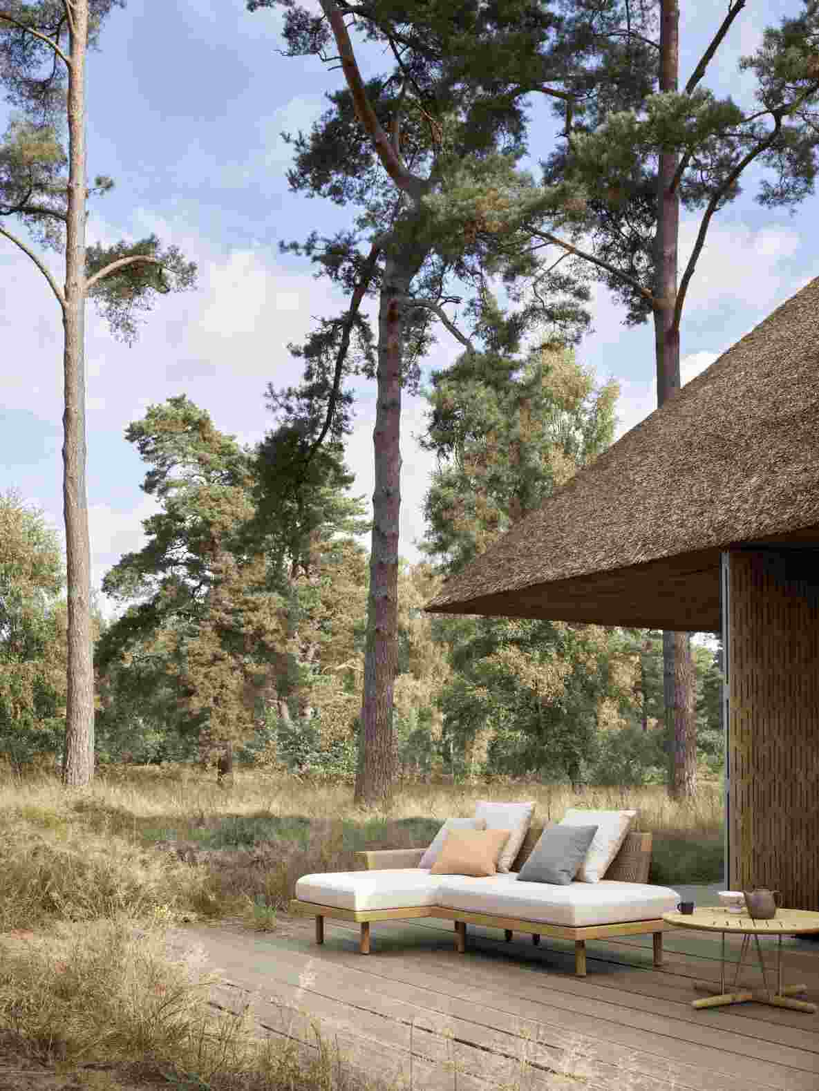 E530 Embrace Outdoor Sofa Modul von Carl Hansen & Søn auf Holzterrasse mit Kissen.