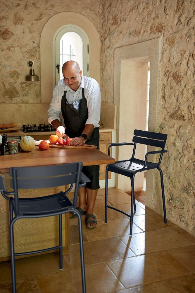 Luxembourg Barstool Barhocker von Fermob in einer Küche mit einer Person beim Kochen.