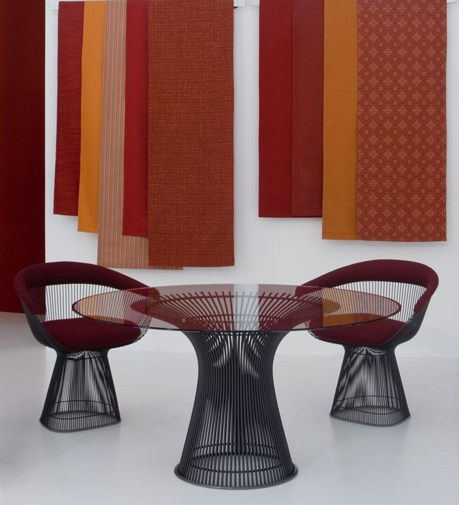 Platner Tisch von Knoll International mit Glasplatte und zwei Platner Stühlen in Rot.