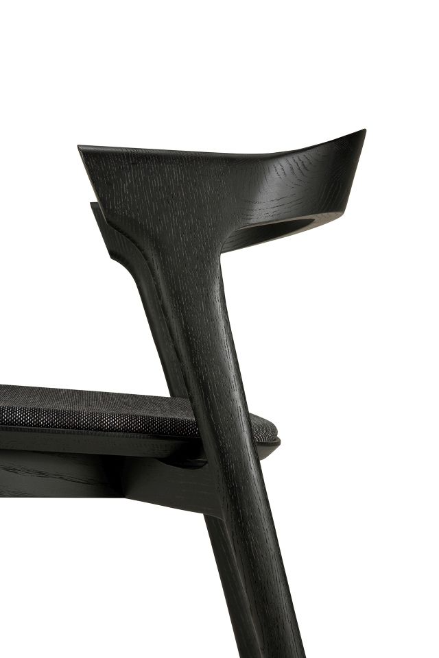 Detailaufnahme des Bok Stuhls: Schwarzes Eichenholz, Stoffbezug. Design Stuhl für Esszimmer und Wohnbereich.