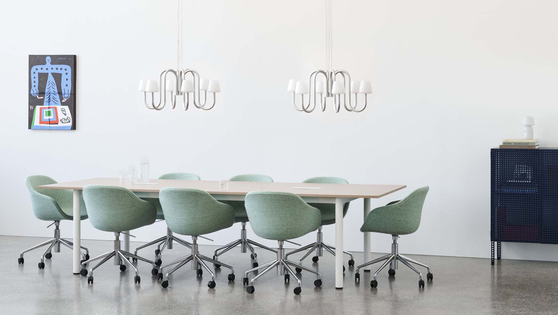 Annex Table Overhang Esstisch von Hay mit grünen Stühlen in einem hellen Konferenzraum.
