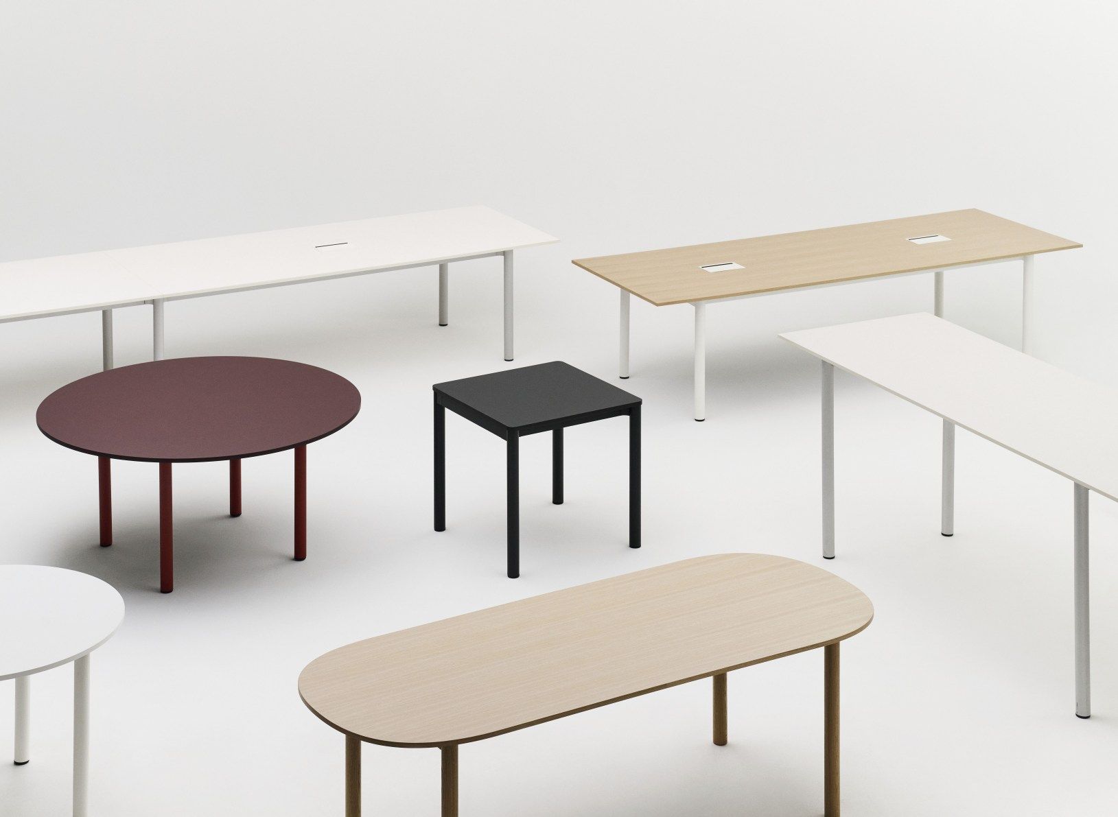 Annex Table Round Esstisch von Hay in Burgunderrot, umgeben von verschiedenen Tischen in unterschiedlichen Formen und Farben.