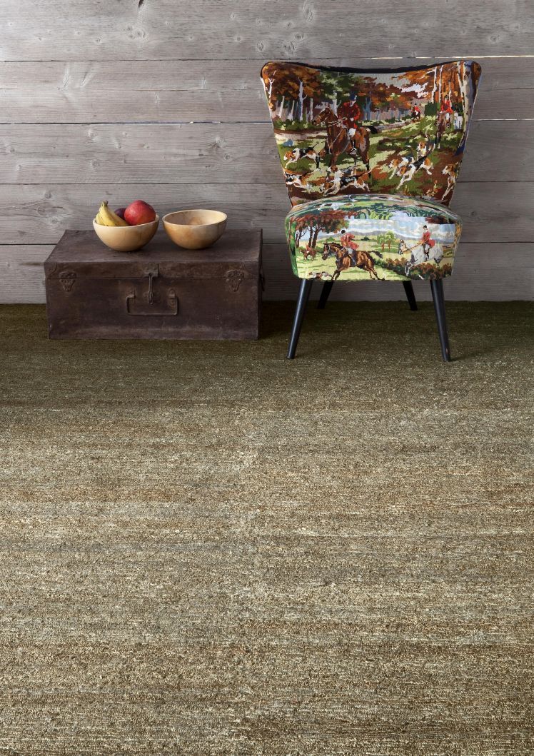 Nanimarquina Earth Rug Teppich, Detailaufnahme des Teppichs in Erdtönen mit Stuhl und Dekoration.