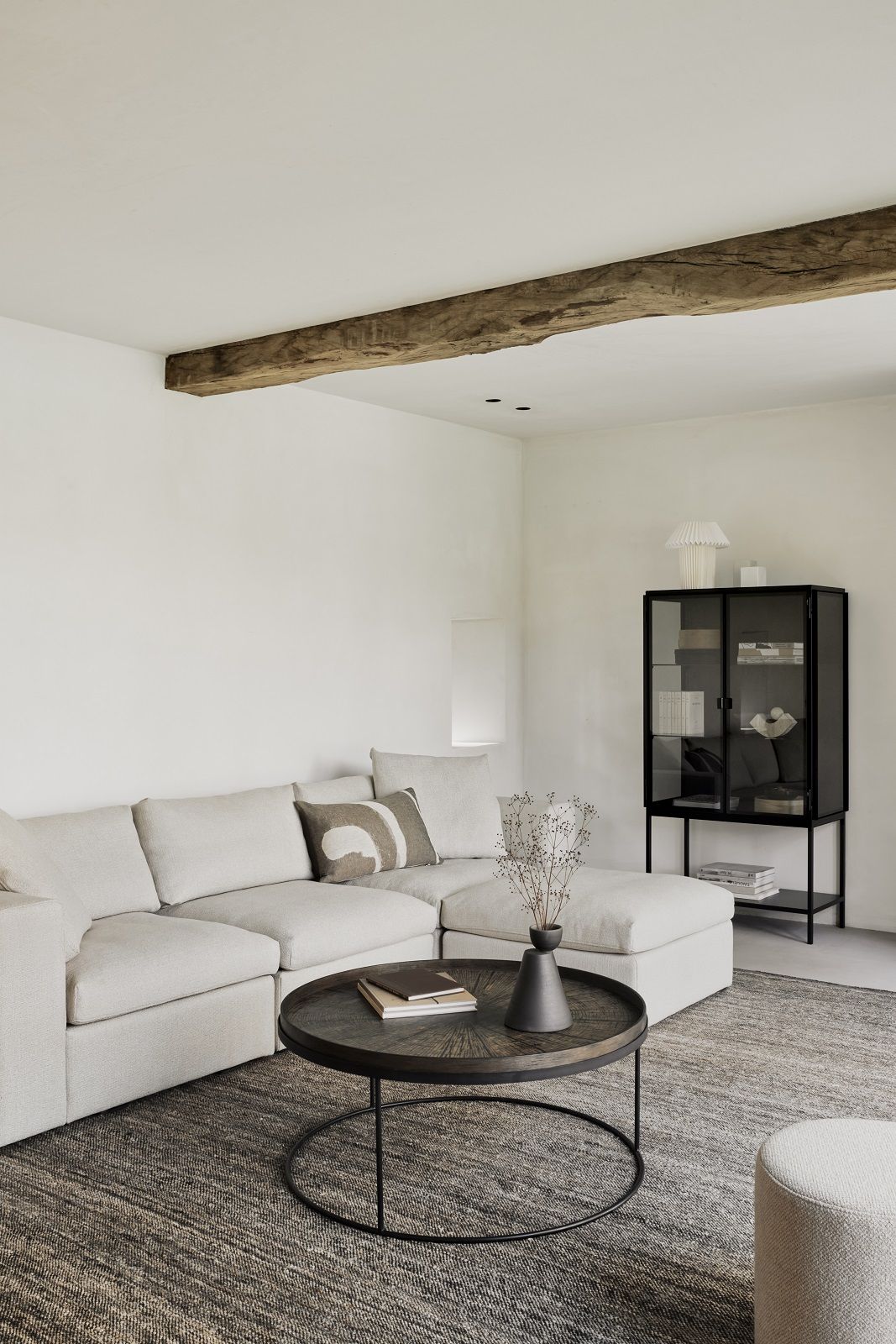 Ethnicraft Couchtisch aus dunklem Holz und Metall im modernen Wohnzimmer mit Sofa und Vitrine.