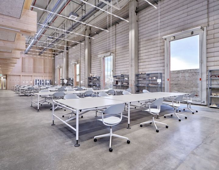 Helle Büroumgebung mit vielen weißen Tischen und grauen Mynt Bürodrehstühlen von Vitra.
