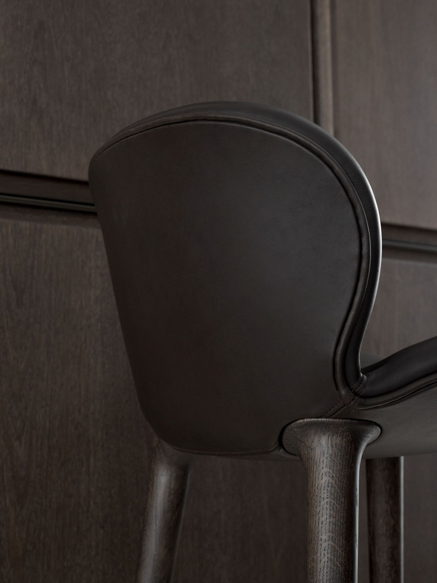 Detailaufnahme des Vipp Lodge Tresenhockers: Dunkelbraunes Leder auf dunklem Eichenholz, modernes Barhocker Design.