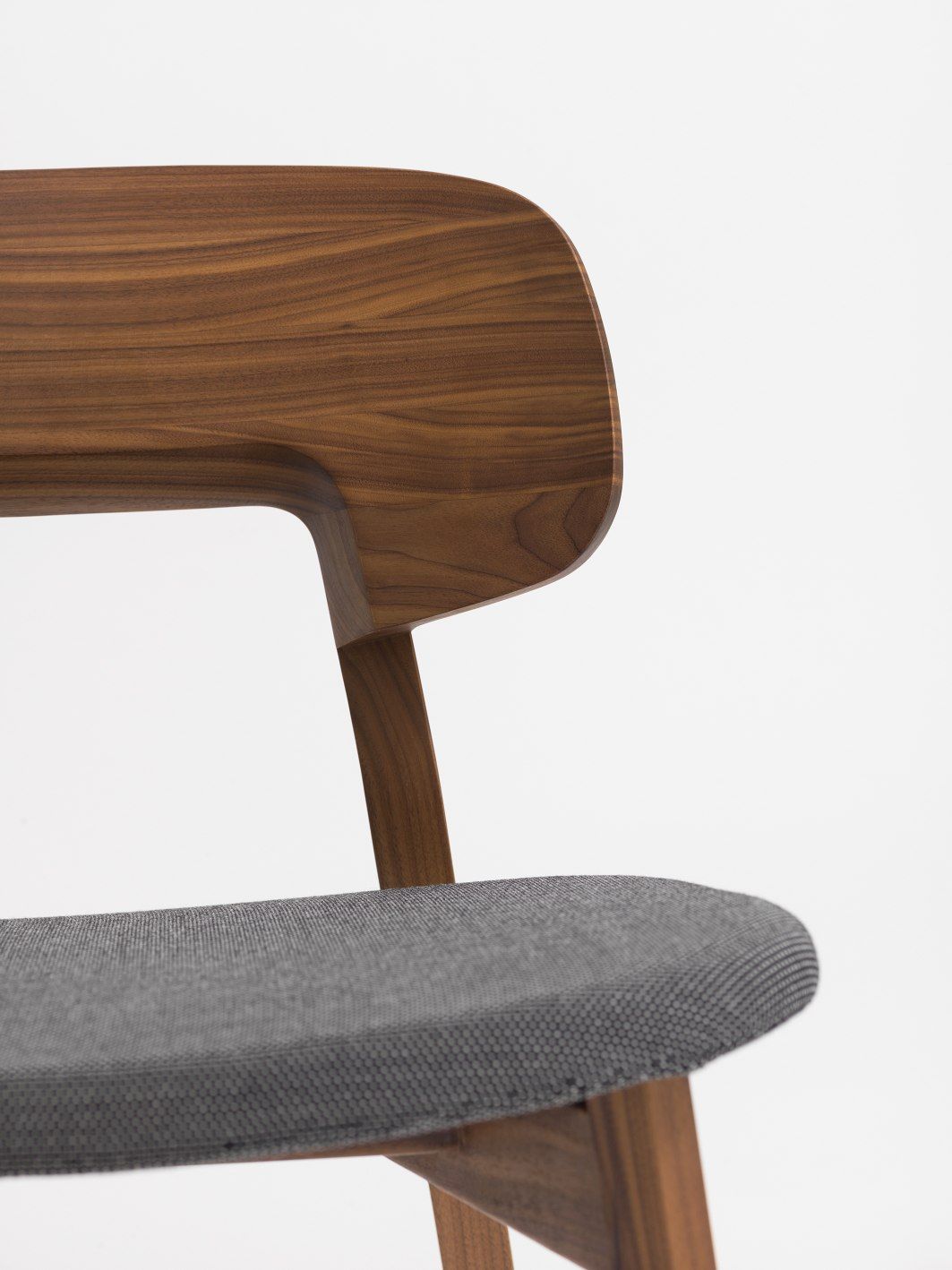Detailaufnahme: Nonoto Cocktailsessel mit grauem Sitzpolster und Rückenlehne aus Walnussholz.