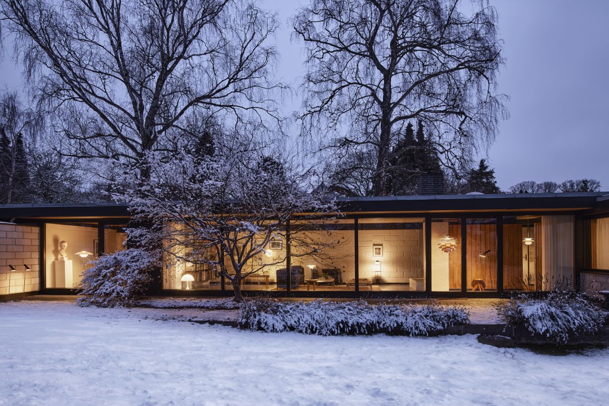 Außenansicht eines modernen Hauses im Winter mit der Patera Pendelleuchte von Louis Poulsen.