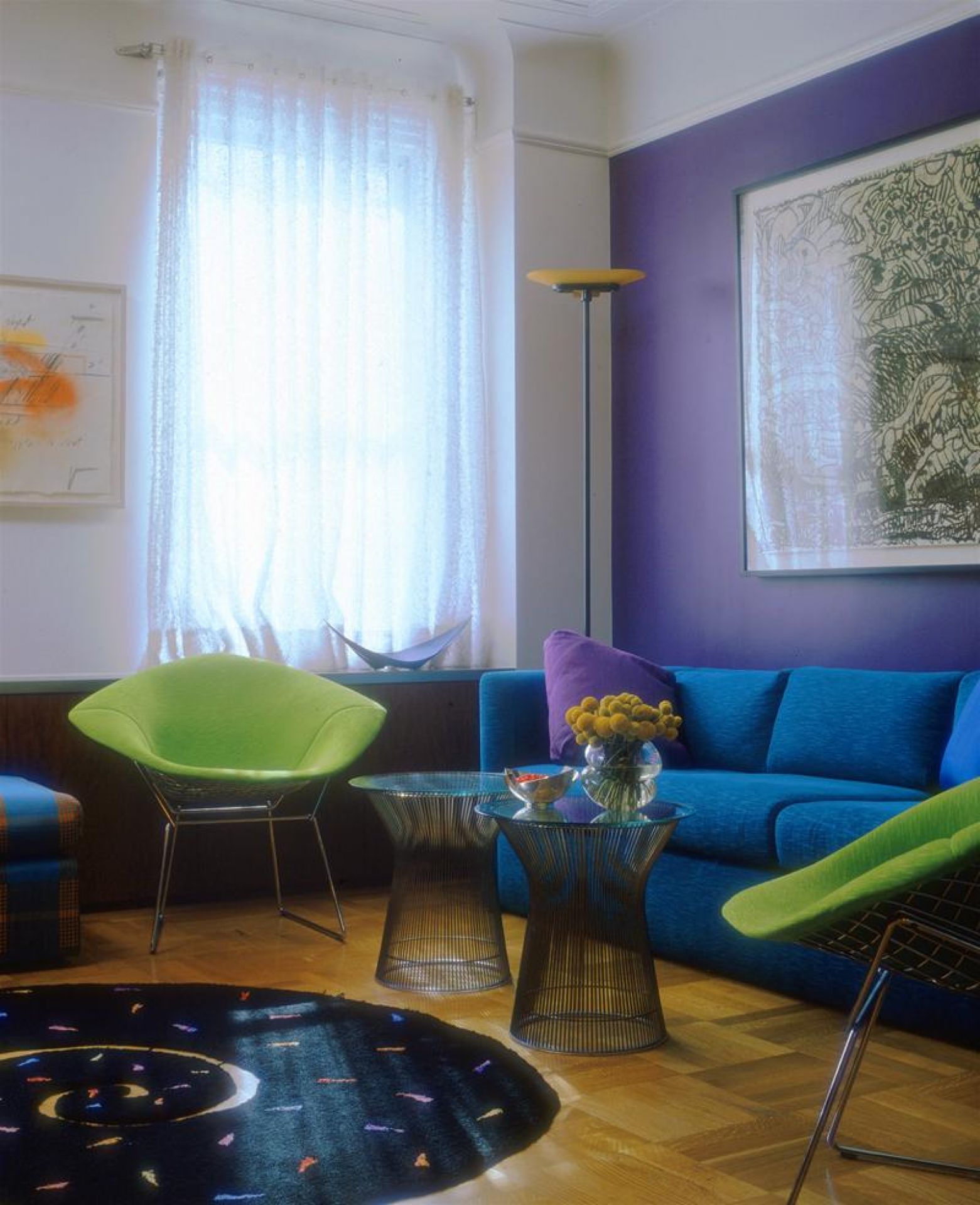 Wohnzimmer Interieur mit blauem Sofa, grünen Sessel und zwei Platner Beistelltischen von Knoll International.