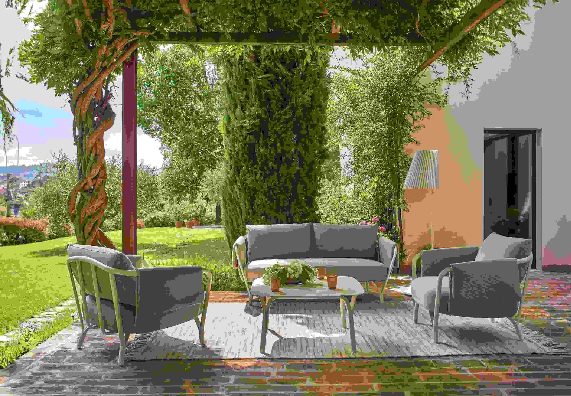Angel 2-Sitzer Sofa Outdoor Emu: Graues Gartensofa und Sessel auf Terrasse mit grüner Umgebung.