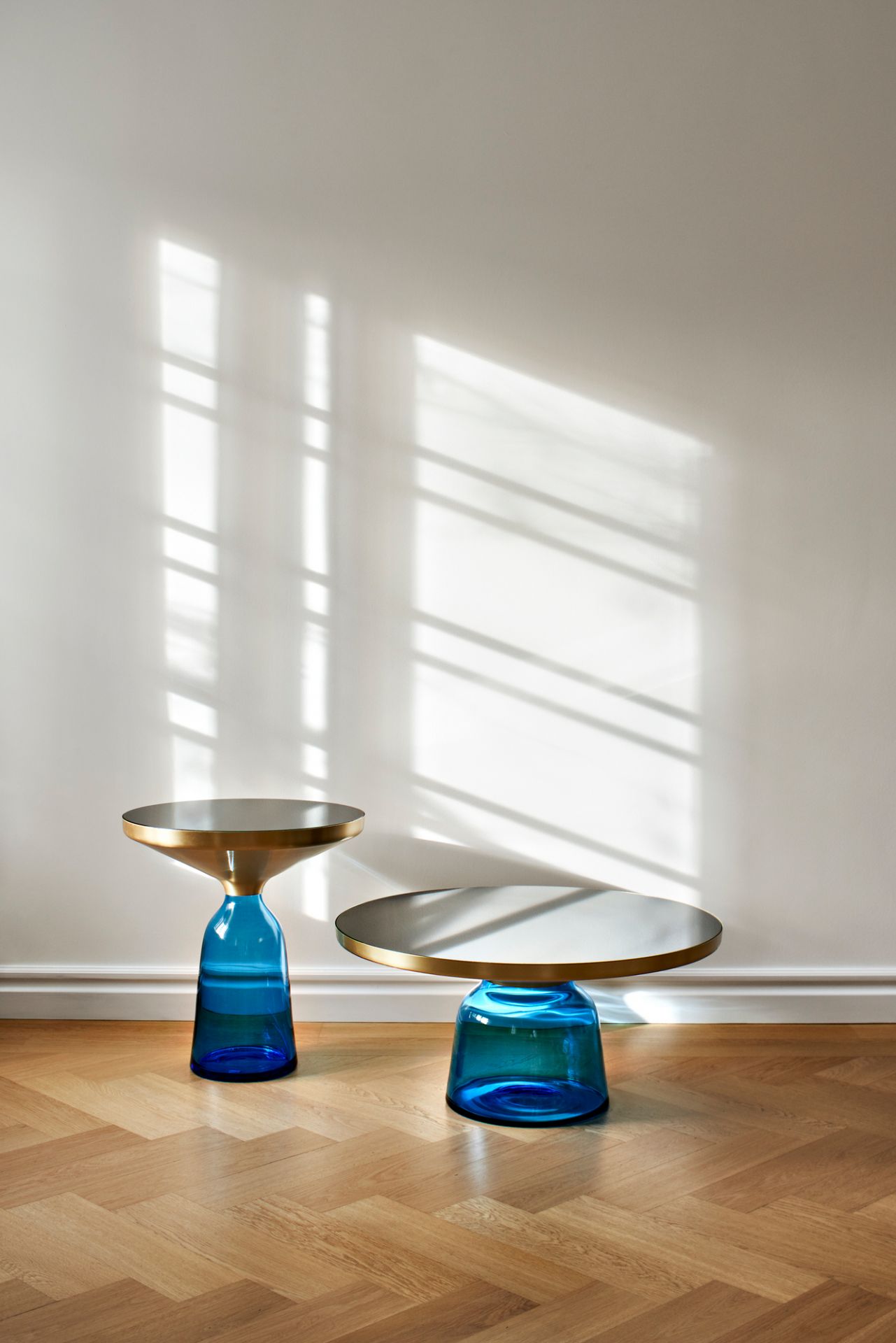 Zwei blaue Bell Coffee Table Couchtische mit Stahlplatte auf einem Holzboden.