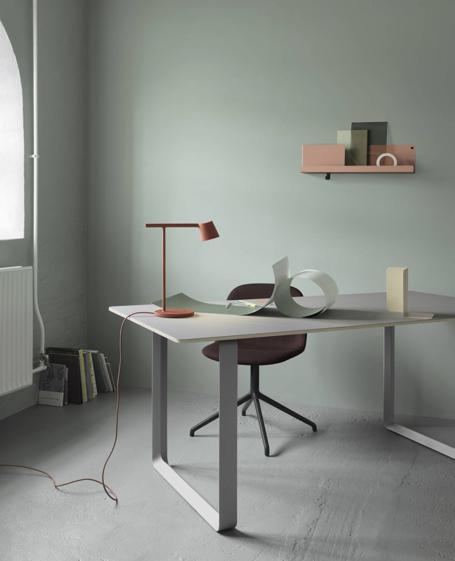 Büro mit Schreibtisch, Lampe, Stuhl und Muuto Folded Shelves Regal in Rosa an der Wand.