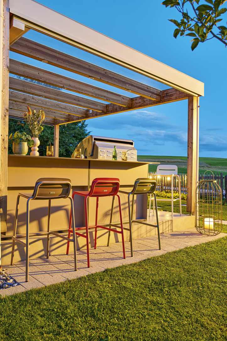 Mehrfarbige Vapio Barhocker von Weishäupl im Außenbereich unter einer Pergola, ideal für Garten und Terrasse.