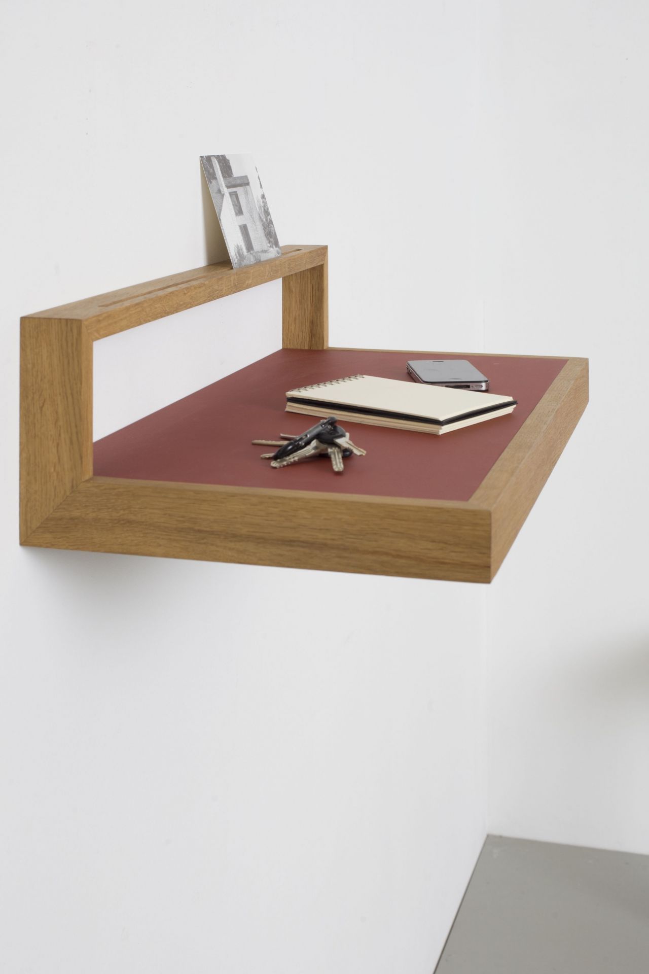Ablageboard buck das kleine b aus Eiche mit Notizbuch, Handy und Schlüssel an der Wand.
