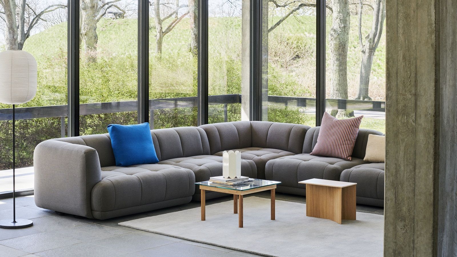 Heller Wohnraum mit grauem Sofa, Stehlampe und Hay Slit Table Wood Beistelltisch aus Holz.