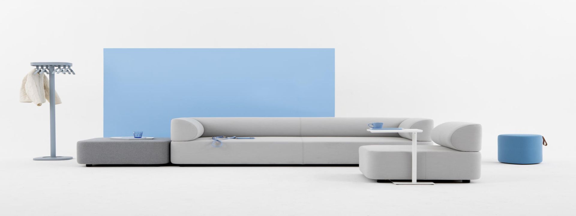 Mezza Sofa Sitzelement von Cascando in Grau mit Hocker, Beistelltisch und Garderobenständer.