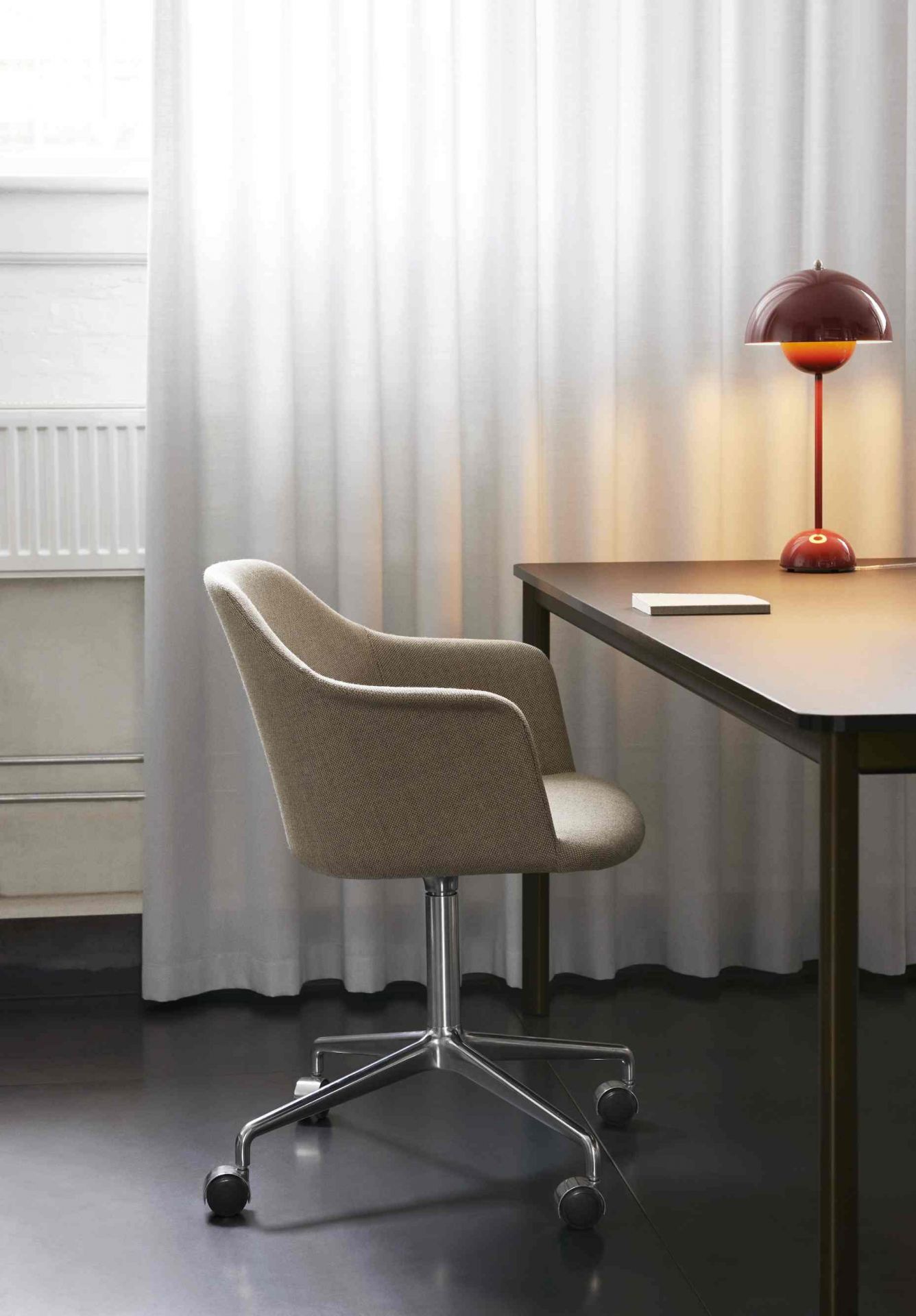 AndTradition Drip Table HW58 mit Bürostuhl und roter Lampe für modernes Arbeitszimmer.