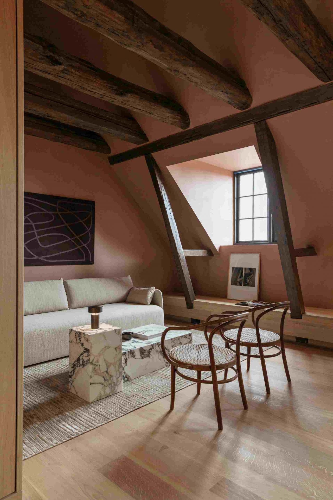 Audo Plinth Beistelltisch aus weißem Carrera Marmor im stilvollen Wohnzimmer mit Sofa.