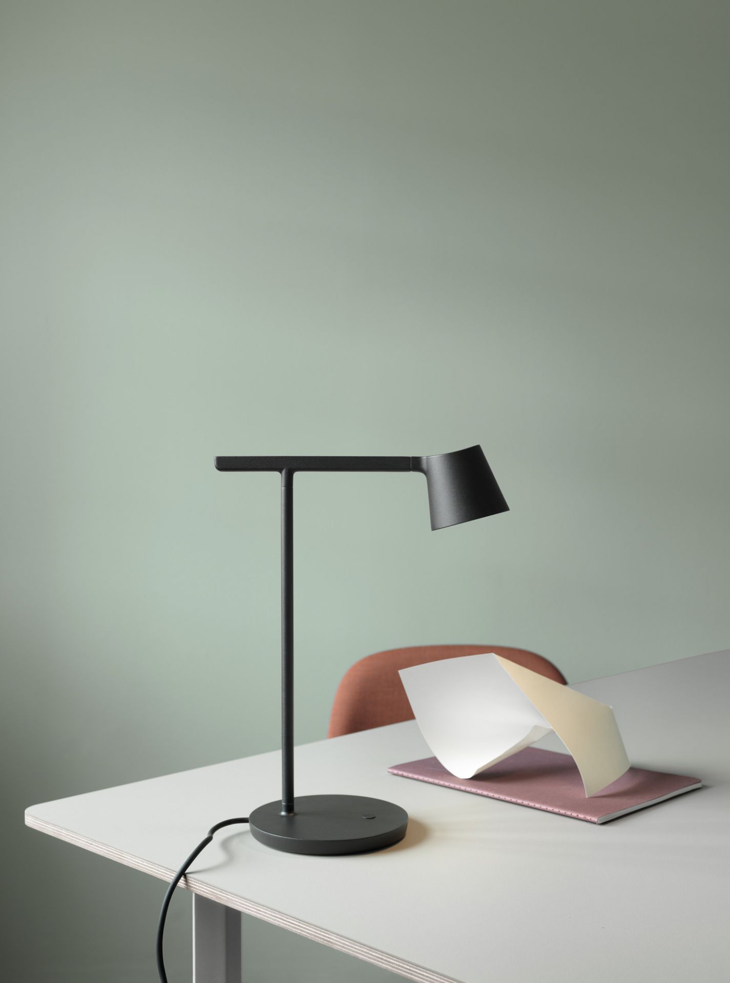 Muuto 70/70 Table Tisch 295x108 cm mit schwarzer Schreibtischlampe, Notizbuch und Papieren auf der Tischplatte.