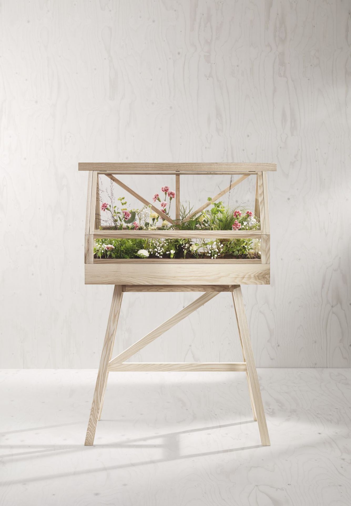 Greenhouse Gewächshaus von Design House Stockholm mit Blumen und Pflanzen auf einem Holzgestell.