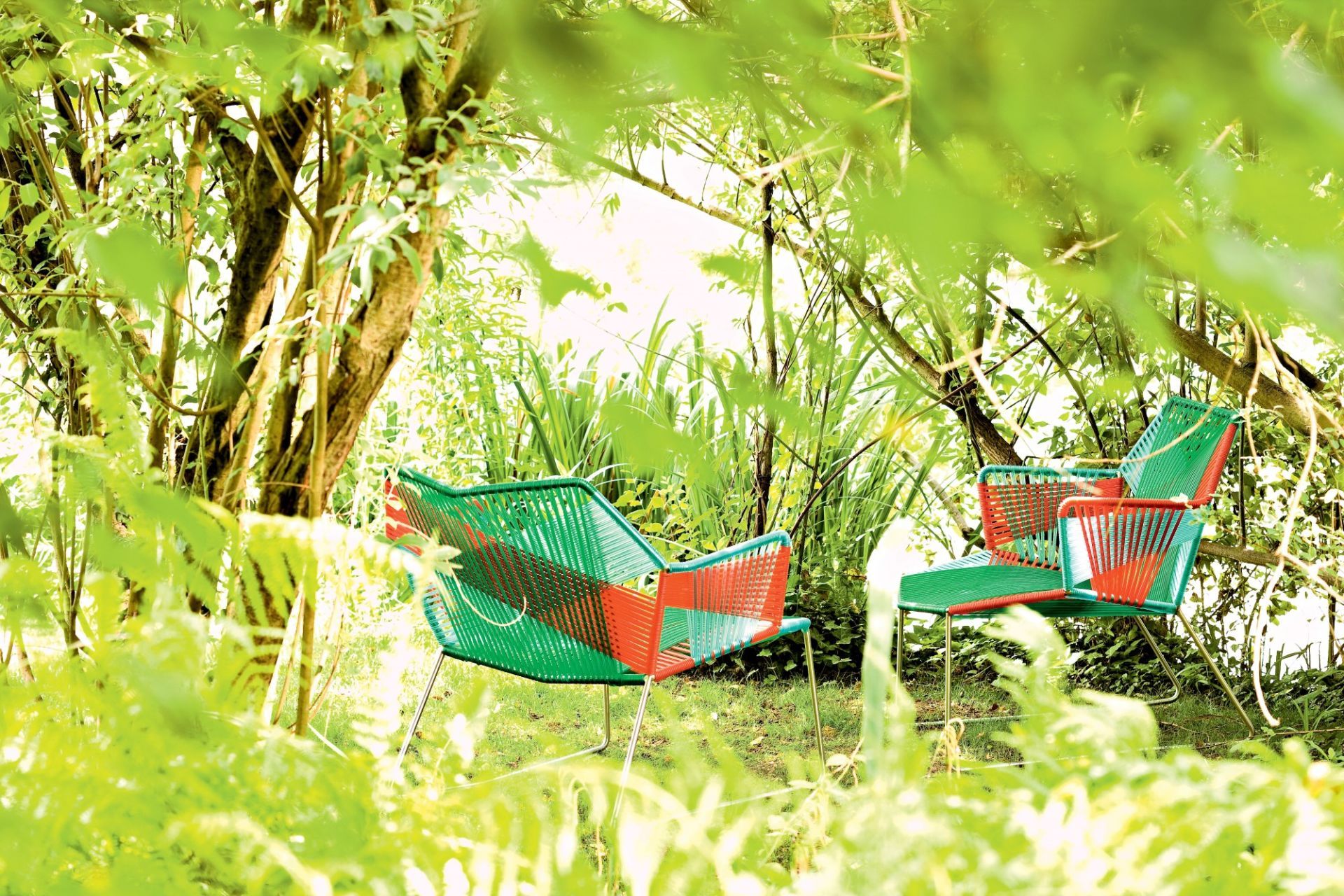 Zwei Tropicalia Outdoor Sessel von Moroso im Garten, grüne und rote Kordel, modernes Gartenmöbel Design.