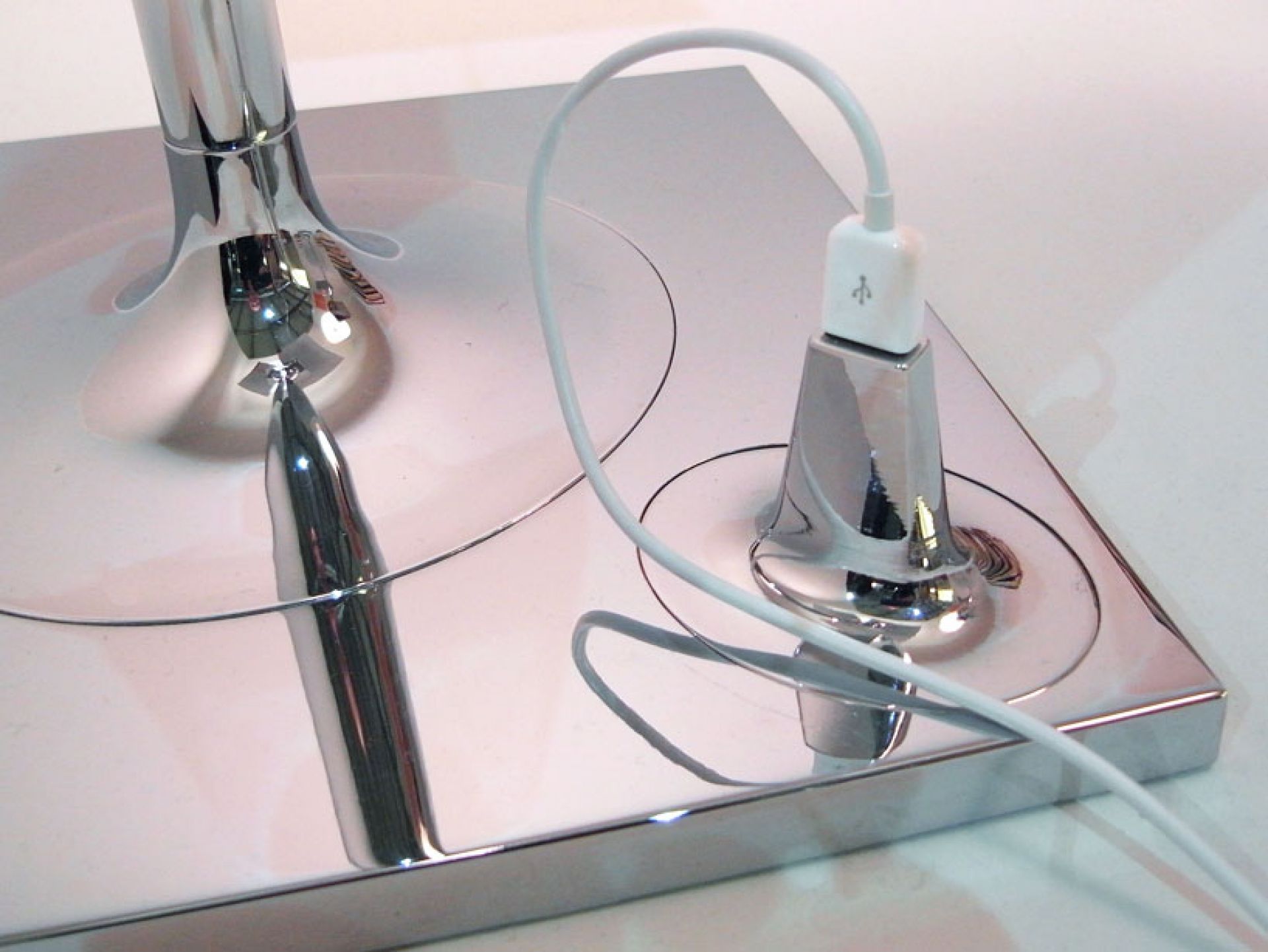 Detailaufnahme der Basis der Bibliotheque Nationale Stehleuchte von Flos mit USB-Ladeanschluss und Kabel.