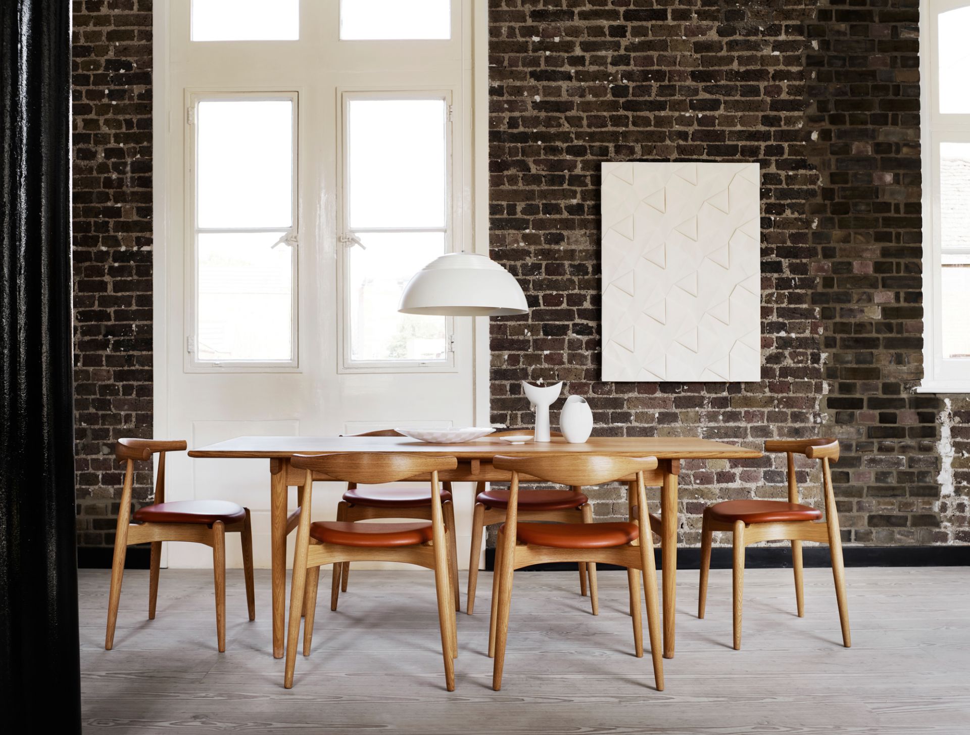 Esszimmer mit CH20 Elbow Stühlen von Carl Hansen, gepolstert mit braunem Leder.