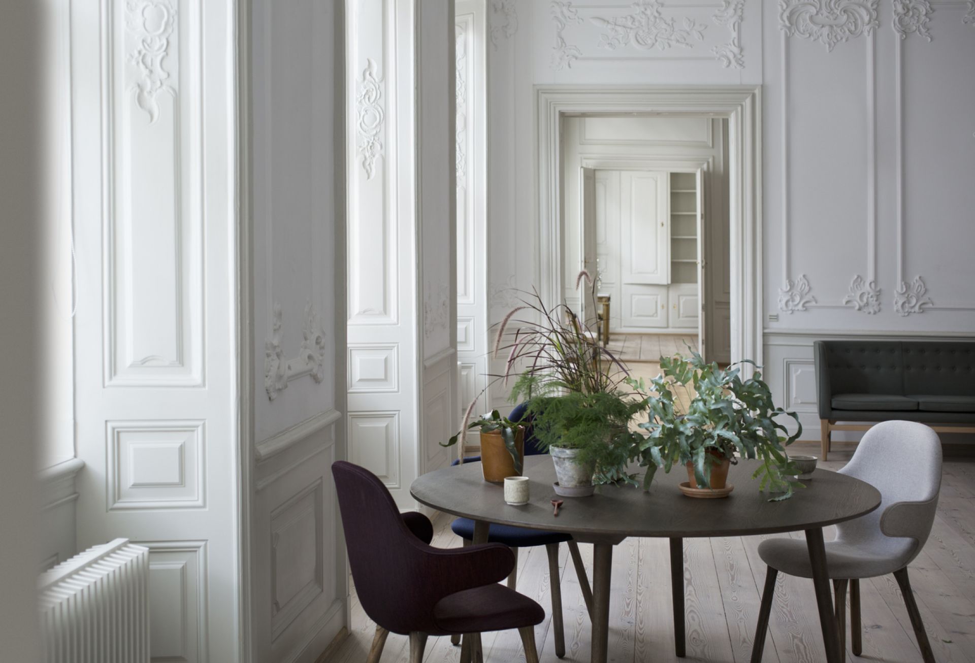 AndTradition Catch Chair JH1 Stuhl in Lila und Grau an einem Esstisch mit Pflanzen.