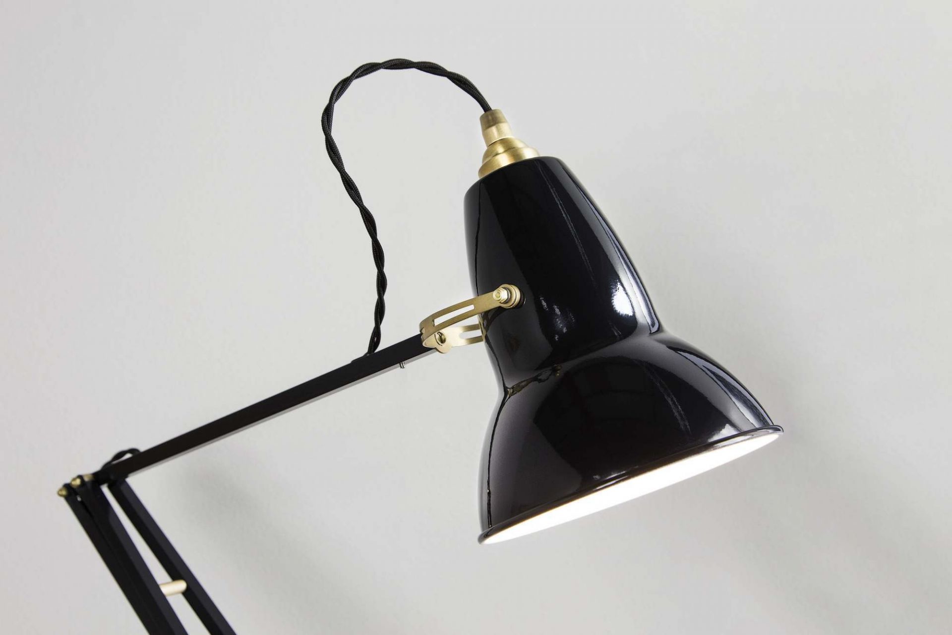 Nahaufnahme der schwarzen Anglepoise Original 1227 Messing Tischleuchte mit verstellbarem Arm und warmem Licht.