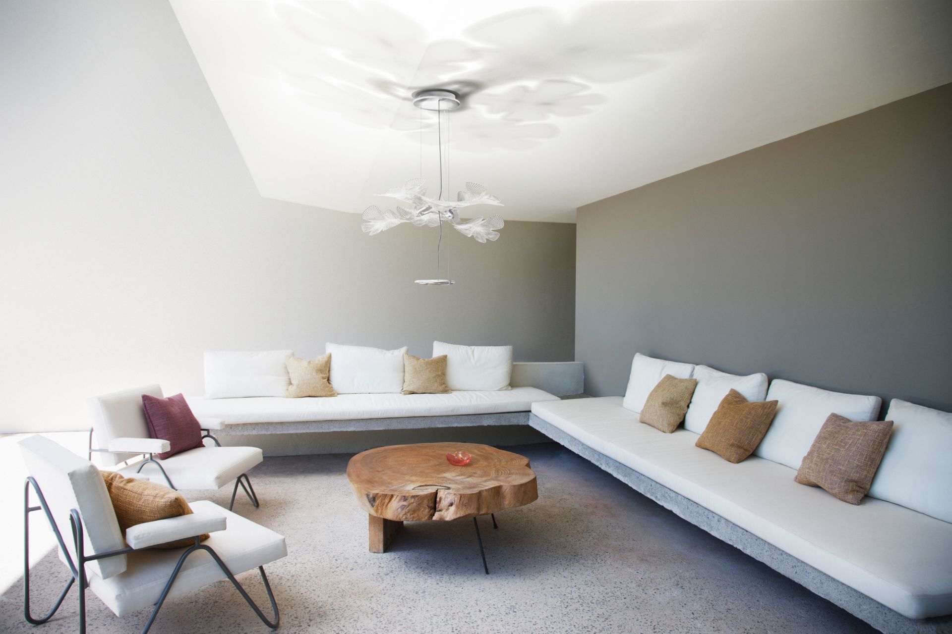 Moderne Chlorophilia Pendelleuchte von Artemide mit transparentem Diffusor und Chromstruktur im Wohnzimmer.