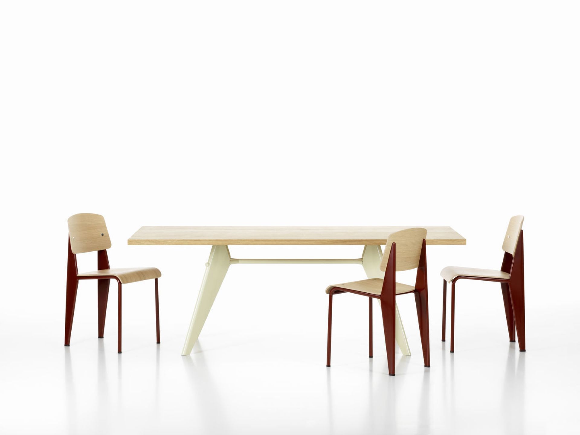Drei Vitra Standard Stühle aus Holz und Stahl an einem Esstisch auf weißem Hintergrund.