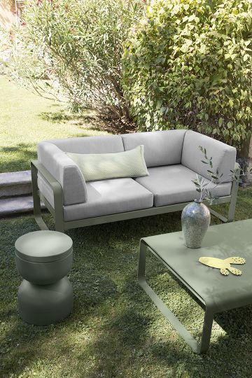 Bellevie Outdoor Sofa von Fermob: Graues 2-Sitzer Lounge Sofa mit Beistelltisch und Couchtisch im Garten.