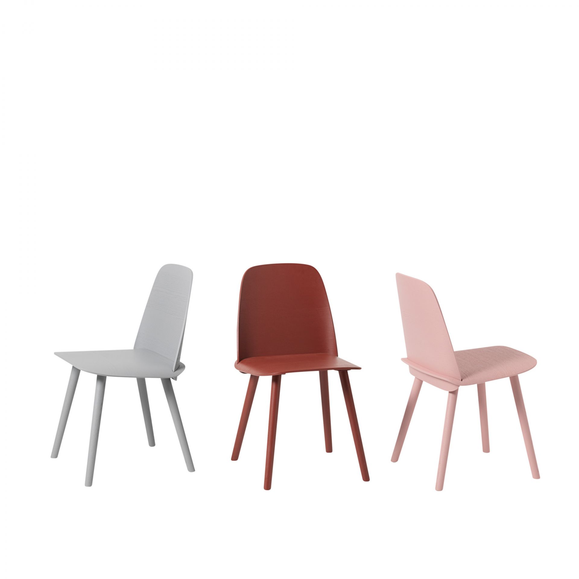 Drei Muuto Nerd Chair Stühle in Grau, Rot und Rosa vor einem weißen Hintergrund.
