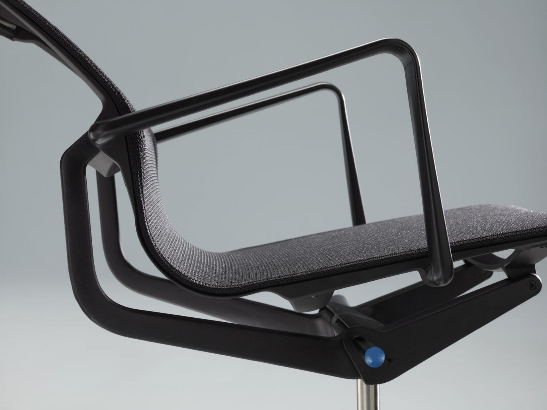 Detailaufnahme des schwarzen Physix Konferenzstuhls von Vitra mit Armlehnen und Netzbezug.
