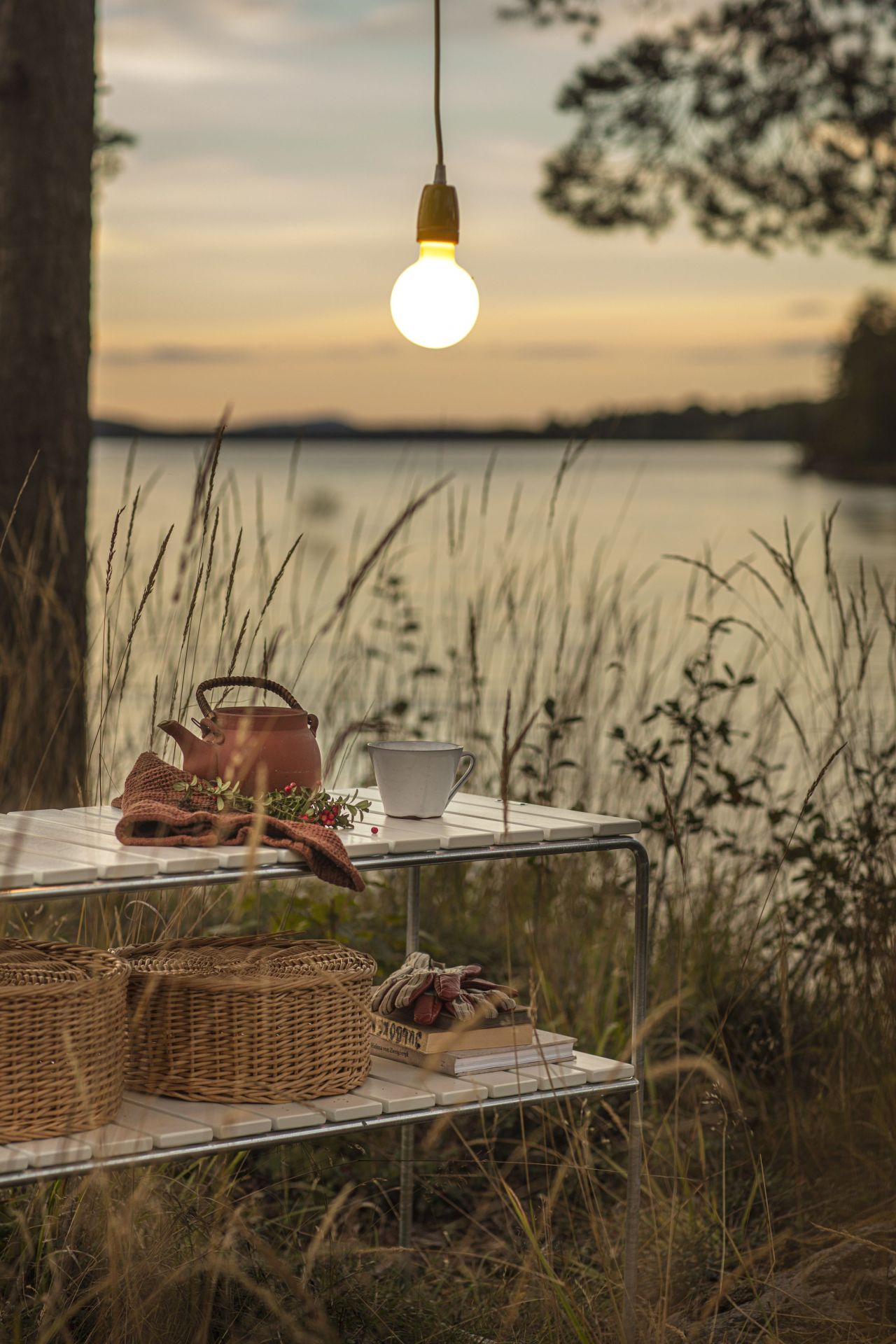 Grythyttan Stalmöbler Beistelltisch L105 Eiche: Outdoor-Szene mit Teekanne, Tasse und Körben auf dem Tisch.