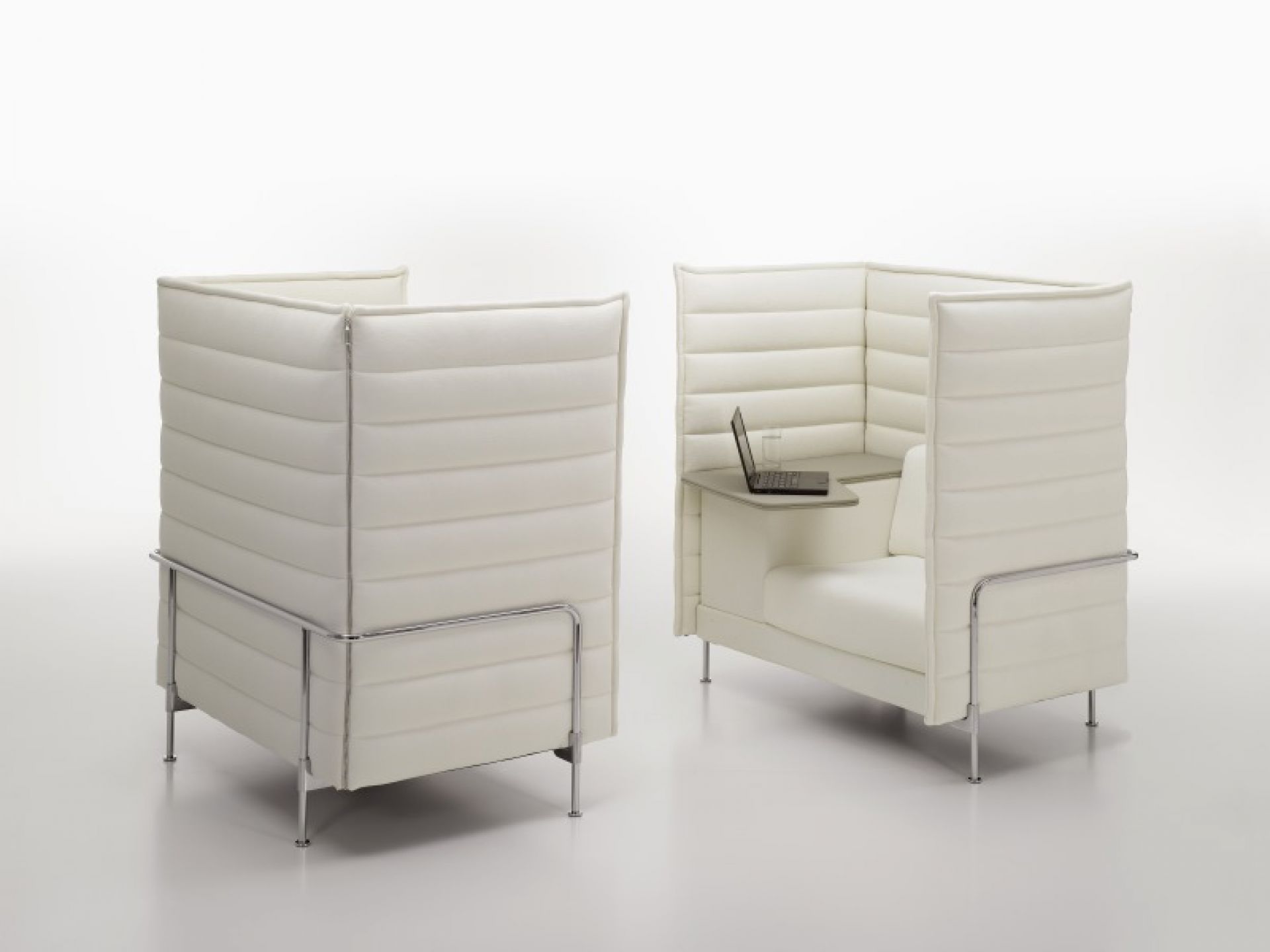 Weißer Alcove Highback Sessel von Vitra mit Tisch und Laptop für konzentriertes Arbeiten.