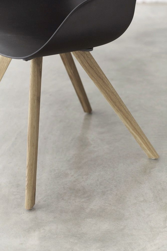 Detailaufnahme vom Yonda Universalstuhl mit Holzgestell, schwarze Sitzschale und helle Holzbeine. Moderner Vierfußstuhl für Esszimmer und Büro.