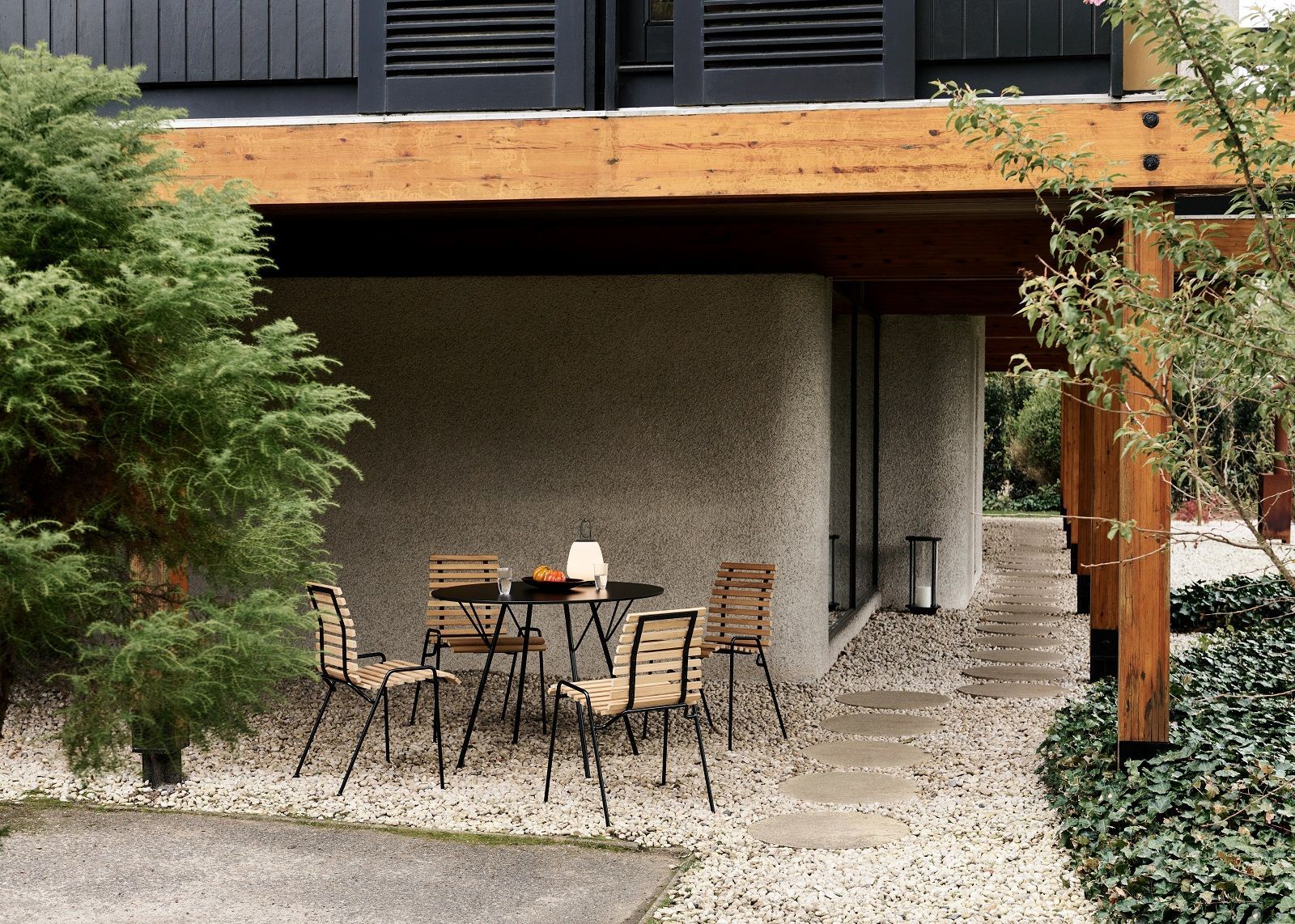 AndTradition RFH Robin Day Esstisch mit vier Stühlen im Garten, minimalistisches Design für den Außenbereich.