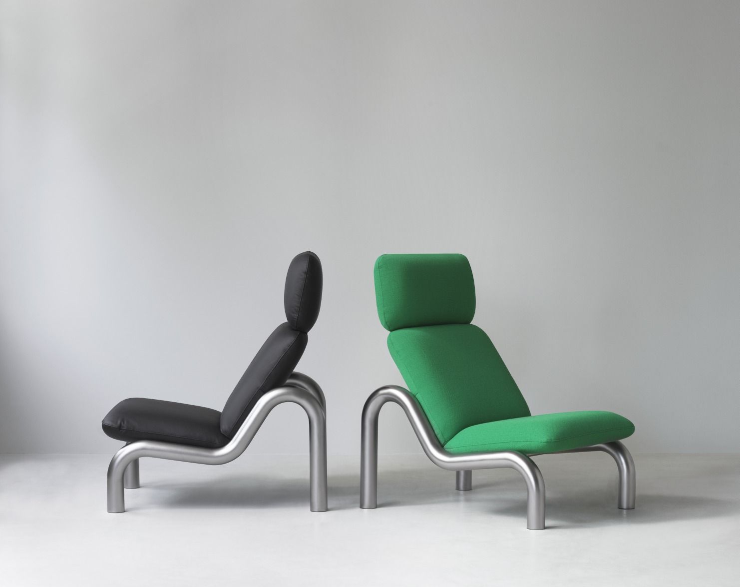 Zwei Tube Lounge Chairs von Normann Copenhagen, einer schwarz, einer grün, mit Stahlrahmen.