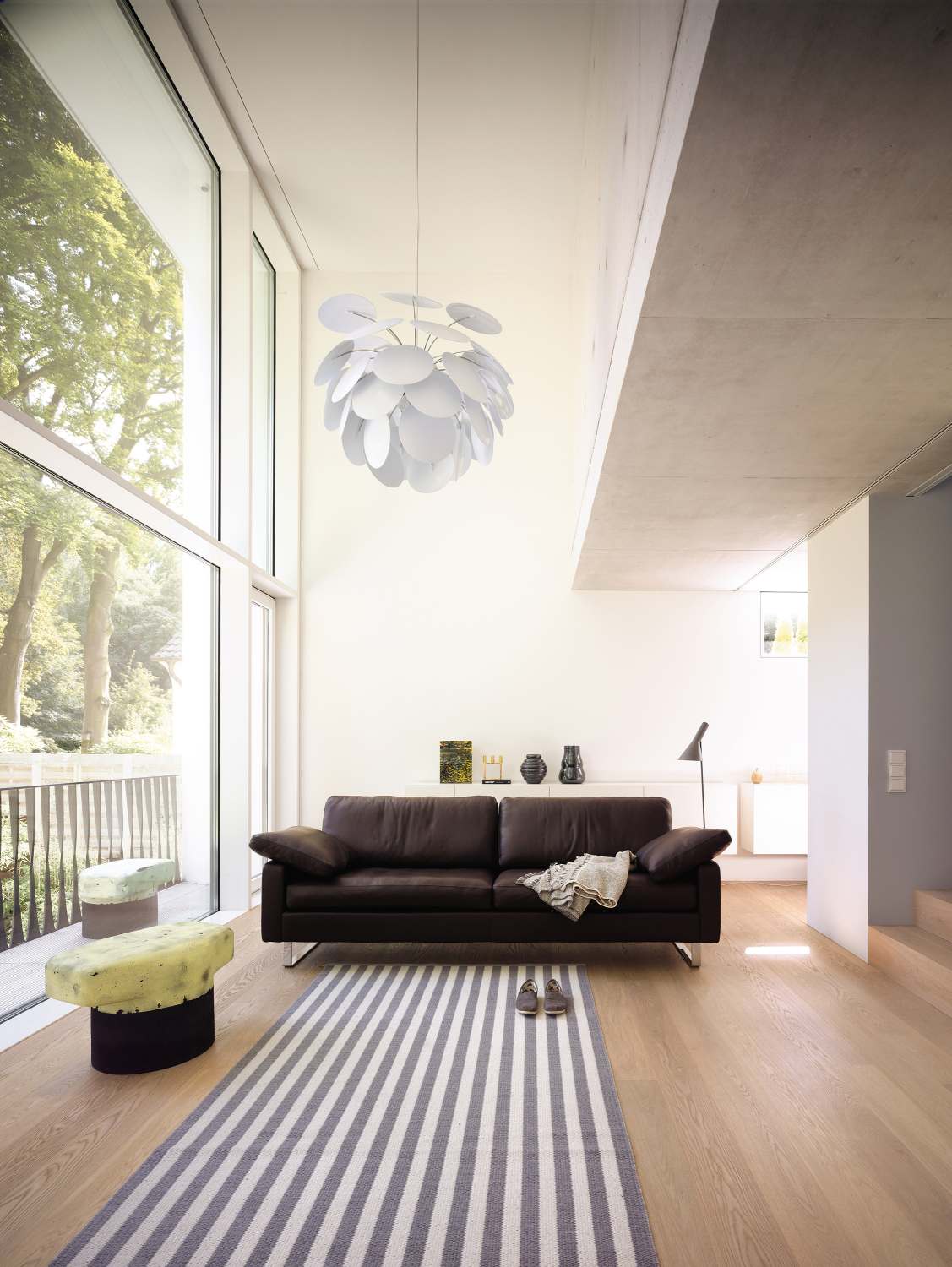 Braunes Conseta Sofa von Cor in modernem Wohnzimmer mit Teppich und Design-Lampe.
