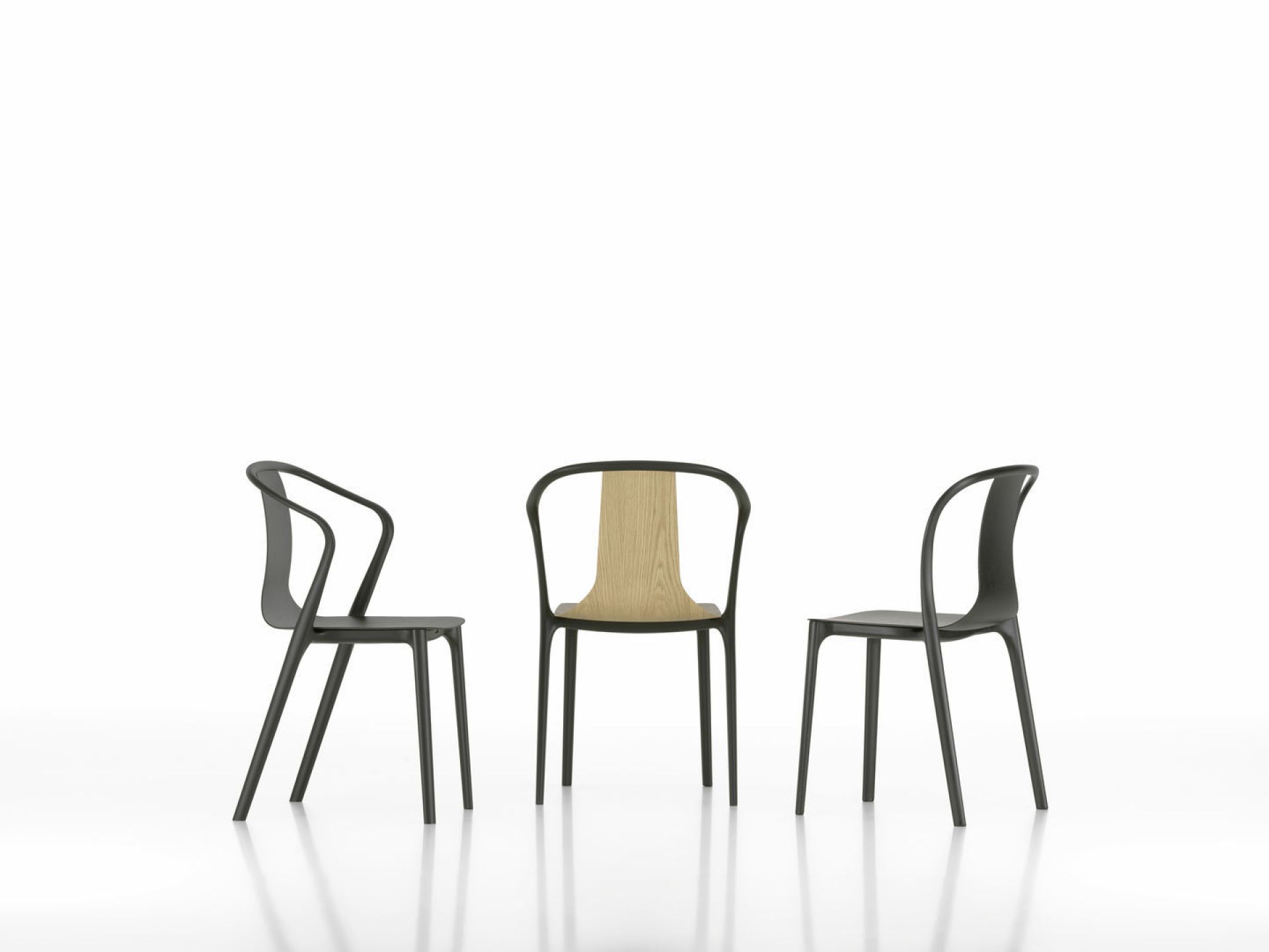 Drei Vitra Belleville Armchair Holzstühle in Schwarz und Naturholz auf weißem Hintergrund.