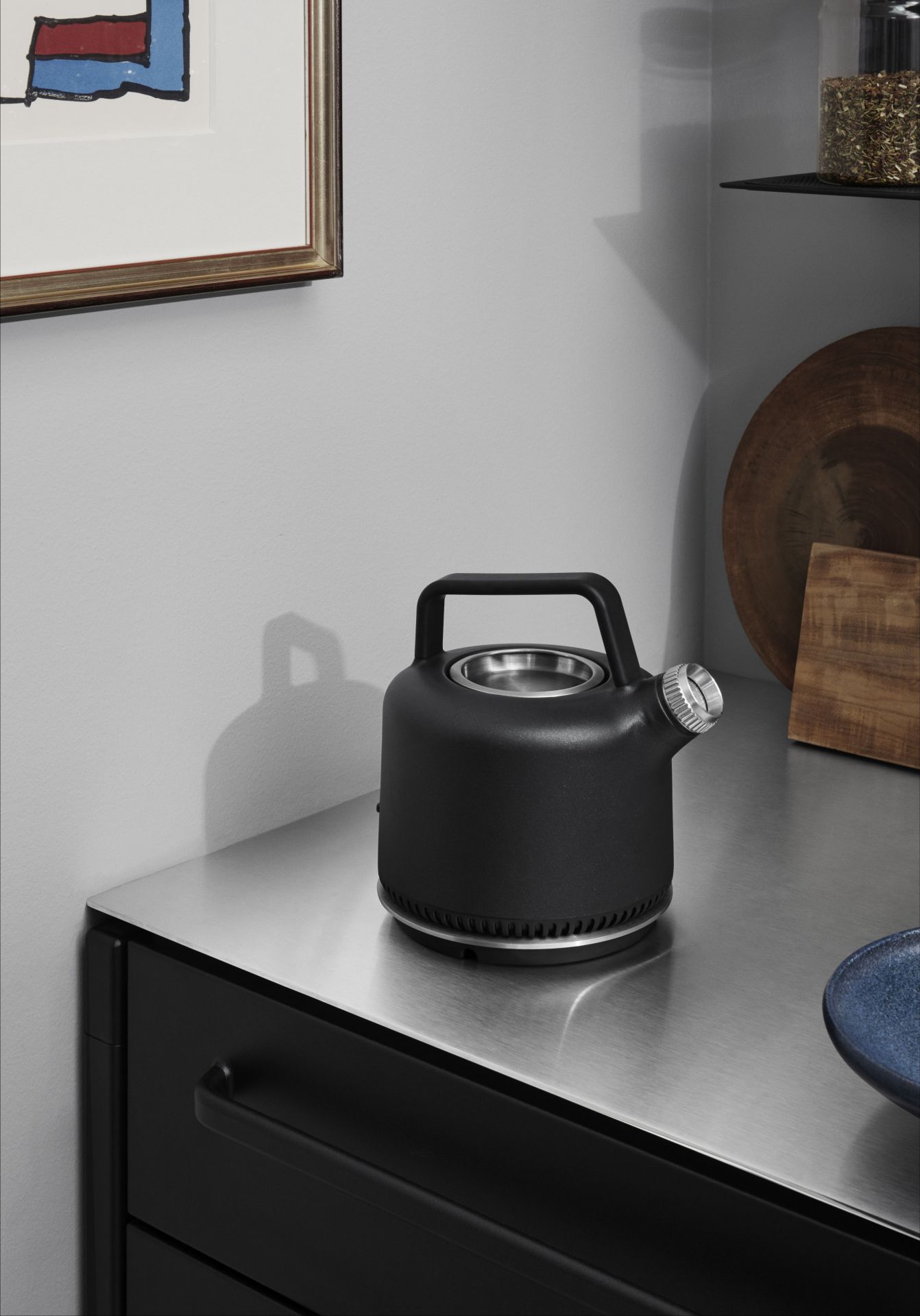 Schwarzer Vipp Wasserkocher aus Edelstahl auf einer Küchenarbeitsplatte, modernes Küchendesign mit Kochutensilien.