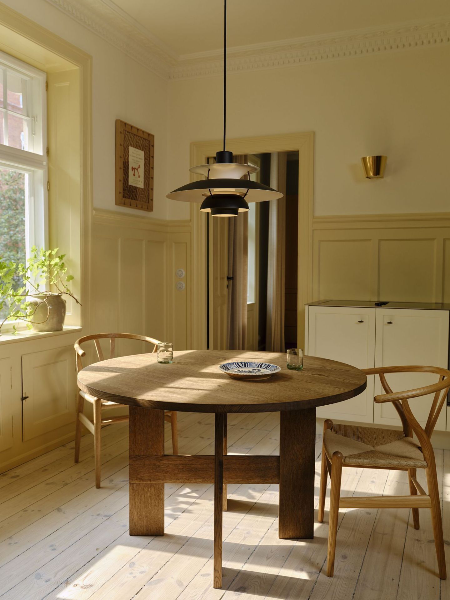 Esszimmer mit runden Holztisch und PH 5 Pendelleuchte MINI BLACK EDITION von Louis Poulsen.
